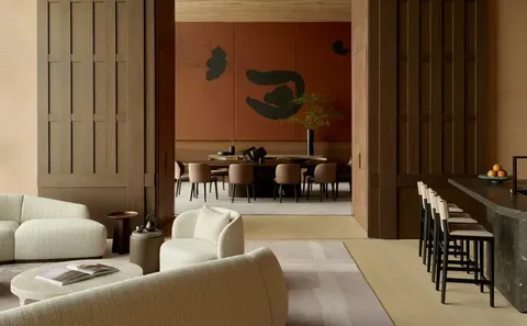 Warm wood-panelled lounge opening onto a private dining room