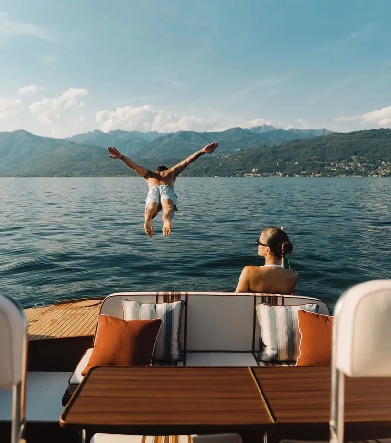 A man leaping into a mountain lake